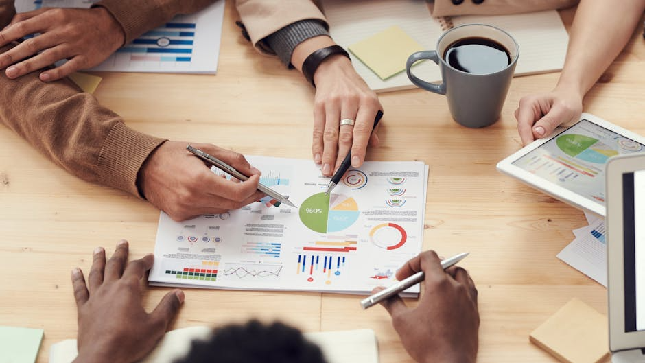 of a team collaborating on a brand strategy document - Facebook community management Team analyzing data and charts