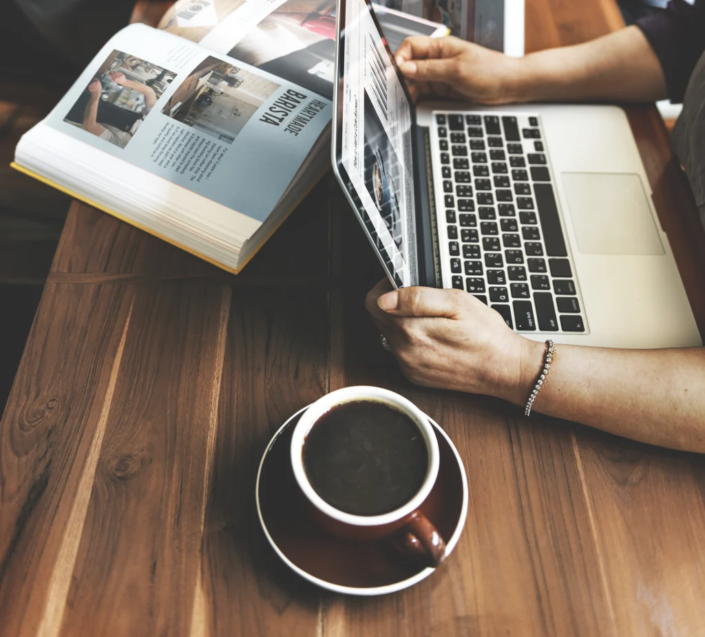 someone drinking coffee with a computer