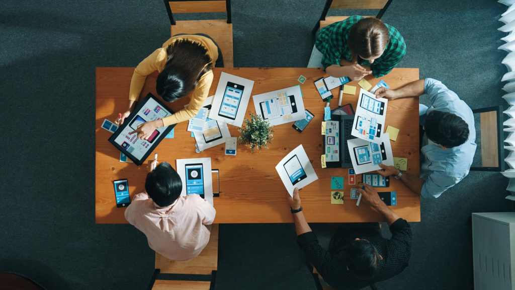 four peoples working around a desk
